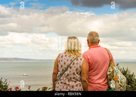 TENBY, Pembrokeshire, Galles - Agosto 2018: l uomo e la donna in Tenby, West Wales, guardando fuori per vedere. Foto Stock