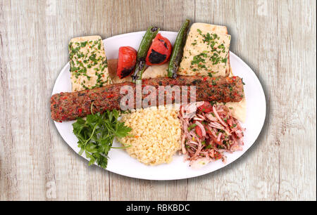 Adana kebab piastra sul pavimento in legno Foto Stock