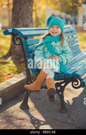 Dolly pin-up toothsome giovane ragazza indossare un turchese light blue Jacket e caldo hat moda abiti eleganti che pongono in autunno il parco di primavera weekend happyl Foto Stock