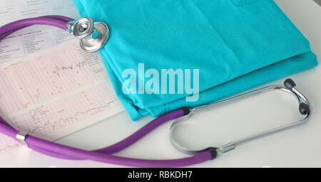 Uno stetoscopio sagomatura di un cuore su una uniforme medica, closeup, il fuoco selettivo. Foto Stock