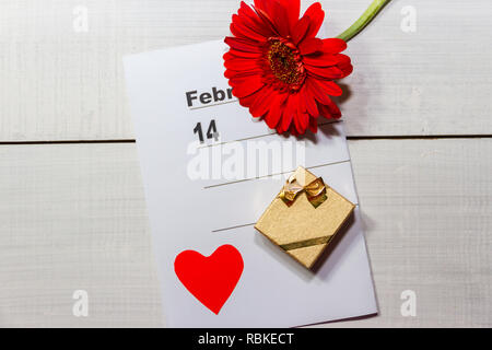 Scatola dorata con anelli di fiori e nota per il giorno di san valentino Foto Stock