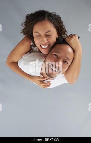 Giovane donna ossessionato con l'uomo sopra vista dall'alto su grigio di sfondo per studio Foto Stock