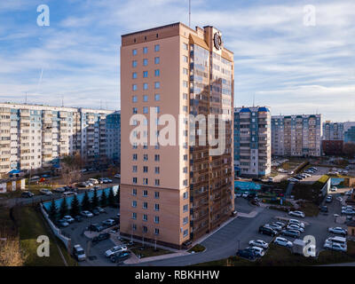 Alto e moderno di casa di lusso di colore dorato con un volante di sterzo sul tetto per la vita che si trova alla periferia della città fra un gran numero di bui Foto Stock