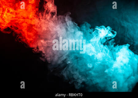 Una colonna di fumo colorato di verde e di colore rosso da un WAP di una forma astratta tendente verso l'alto su un isolato nero lo sfondo. Foto Stock