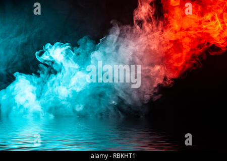 Una colonna di fumo colorato di verde e di colore rosso da un WAP di una forma astratta tendente verso l'alto su un nero sfondo isolato al di sopra di un fiume con smal Foto Stock