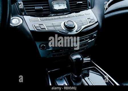 Auto di lusso all'interno. Interno del prestige auto moderna. Comodi posti a sedere in pelle. Nero in pelle traforata cockpit. Pulsanti del controllo multimediale in black leathe Foto Stock