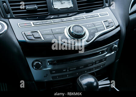 Auto di lusso all'interno. Interno del prestige auto moderna. Comodi posti a sedere in pelle. Nero in pelle traforata cockpit. Pulsanti del controllo multimediale in black leathe Foto Stock