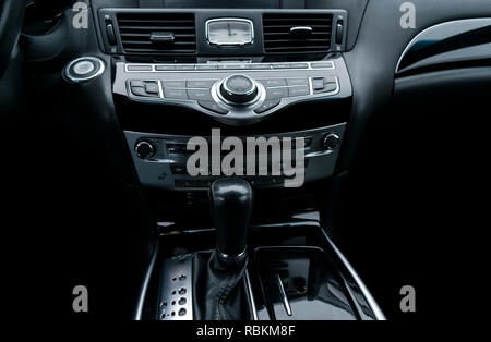 Auto di lusso all'interno. Interno del prestige auto moderna. Comodi posti a sedere in pelle. Nero in pelle traforata cockpit. Pulsanti del controllo multimediale in black leathe Foto Stock