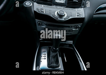 Auto di lusso all'interno. Interno del prestige auto moderna. Comodi posti a sedere in pelle. Nero in pelle traforata cockpit. Pulsanti del controllo multimediale in black leathe Foto Stock