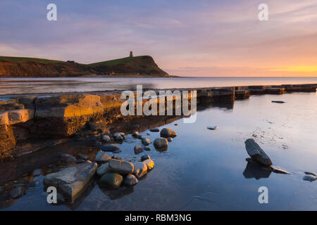 Kimmeridge, Dorset, Regno Unito. Xi gen, 2019. Regno Unito Meteo. Un inverno spettacolare tramonto visto dalla spiaggia e cenge a Kimmeridge Bay in Dorset Jurassic Coast guardando verso Clavell Torre. Credito Foto: Graham Hunt/Alamy Live News Foto Stock