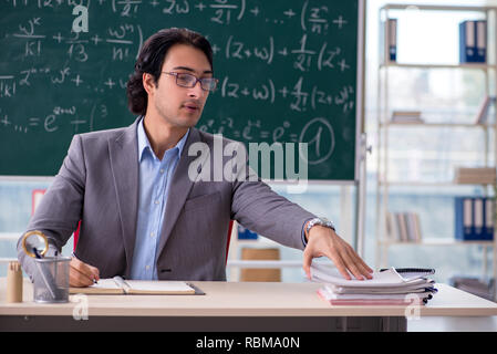 Bel giovane insegnante di matematica in aula Foto Stock