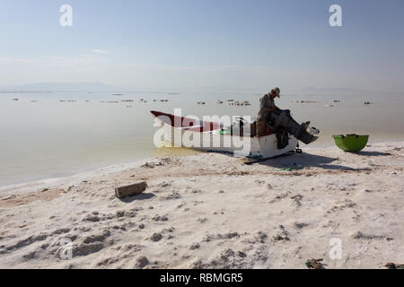 Un barcaiolo con la sua barca sulla spiaggia del lago di Urmia, West Azerbaijan provincia, Iran Foto Stock