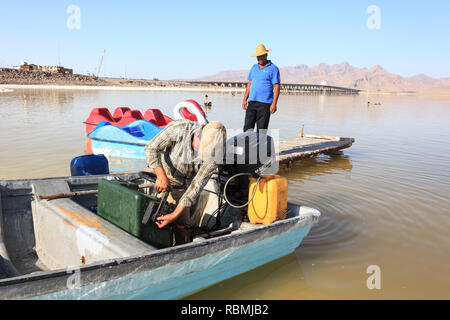 Un barcaiolo con la sua barca sulla spiaggia del lago di Urmia, West Azerbaijan provincia, Iran Foto Stock