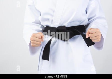 I pugni di donna che indossa il karate suit su sfondo bianco Foto Stock