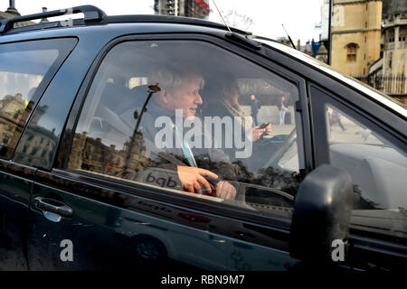 Ex ministro degli affari esteri del Regno Unito Boris Johnson regola la sua cintura di sicurezza come egli lascia le Case del Parlamento europeo a Londra. Foto Stock