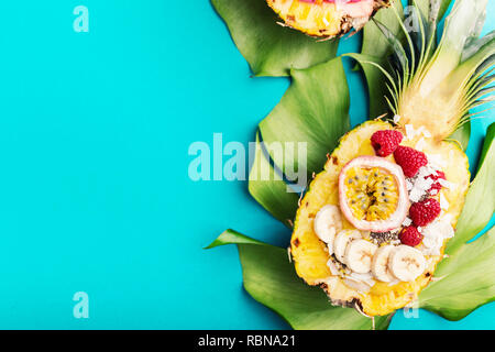 Gustoso frullato di appetitosi bocce servita in metà ananas decorato con taglio frutto della passione, scaglie di noce di cocco e semi di chia.la vita sana pulire mangiare co Foto Stock