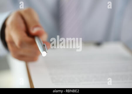 Braccio maschio in tuta offerta sotto forma di contratto su Foto Stock