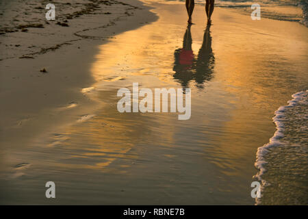 Silhouette di un paio di camminare sulla spiaggia durante il tramonto a Cuba Foto Stock