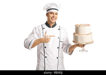 Allegro chef maschio tenendo una torta e che puntano ad esso isolato su sfondo bianco Foto Stock
