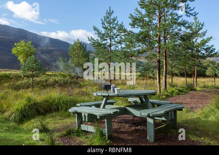 La prima colazione preparata su un fornello da campeggio montato su un tavolo da picnic, vicino al villaggio di Torridon, Scozia Foto Stock