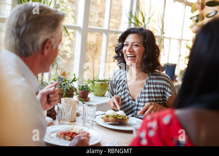 Ridendo donna ridere con amico maschio ad un cafe, close up Foto Stock