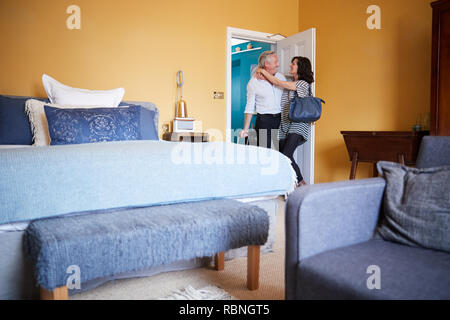 Coppia di mezza età abbracciando nella porta di una stanza di un hotel Foto Stock