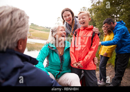 Generazione Multi family spanding tempo insieme sulla riva di un lago, Lake District, REGNO UNITO Foto Stock