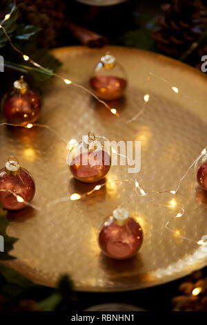 Close up baubles di Natale su una tabella di oro a caldo con candele, il fuoco selettivo Foto Stock