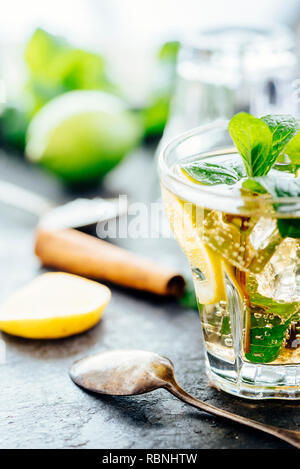 Cocktail Mojito rendendo presso il bar. Cocktail ingredienti per la festa estiva una bibita rinfrescante preparazione. Lime, menta, zucchero, vodka e gin sul rustico scuro ba Foto Stock