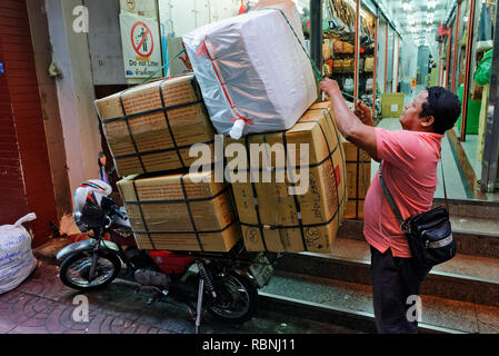 Ragazzo delle consegne sul motociclo nella strada stretta Soi Wanit 1, Chinatown, Bangkok Foto Stock