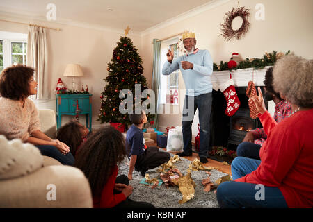 Generazione Multi Family Playing Game di corali come si festeggia il Natale a casa insieme Foto Stock
