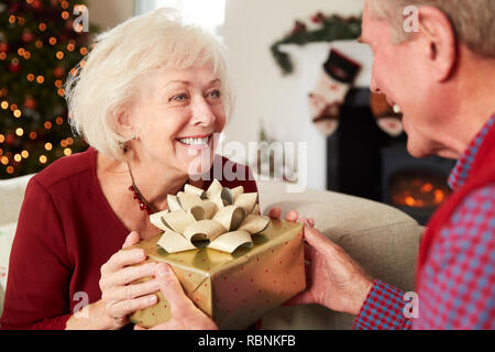 Emozionato madre riceve un regalo di Natale da figlia a casa Foto Stock