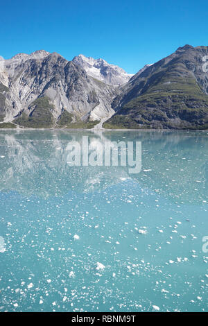 Il ghiaccio galleggiante sulla superficie del lago con le montagne sullo sfondo in Alaska Foto Stock