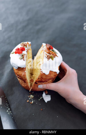 Tagliare la torta di Pasqua in mano womans. La pasqua ortodossa tradizionale pane dolce, kulich. Vacanze di Pasqua a colazione. Taglio femminile torta di Pasqua Foto Stock
