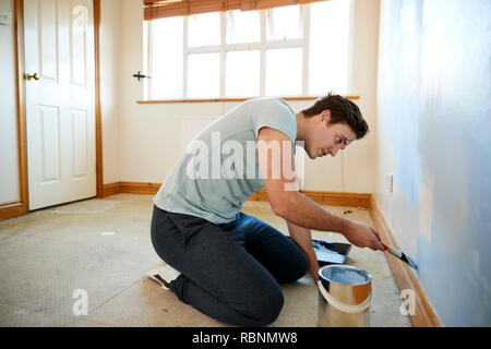 L'uomo la decorazione di stanza in casa nuova parete di verniciatura Foto Stock