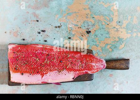 Gravlax, barbabietole scandinavo indurito salmone speziato sul bordo, vista dall'alto, salate pesce rosso Foto Stock