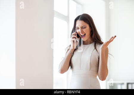 Felice bella donna urla nel telefono cellulare. Buone notizie idea Foto Stock