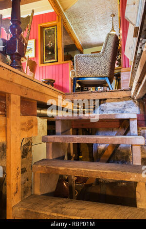 Vista parziale della sala da pranzo della gamba del tavolo e sedie visto da vecchie scale di legno nel seminterrato all'interno di un vecchio circa 1850 Canadiana cottage in stile home Foto Stock