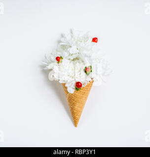 Bel fiore unico nel cono gelato su sfondo bianco. Composizioni floreali, piatto per lo styling dei laici. Vista dall'alto. Creative ancora vita idea della molla Foto Stock