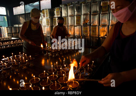 I monaci buddisti si accendono lampade a olio in occasione del Buddha Purnima. Foto Stock