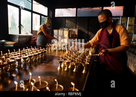 I monaci buddisti si accendono lampade a olio in occasione del Buddha Purnima. Foto Stock