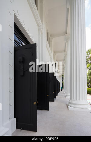 Vista verticale di una fila di porte nere pesanti in basso all'entrata del College of Medicine Building, Singapore. Foto Stock