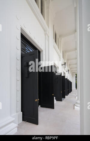 Vista verticale delle porte nere dell'ingresso sono aperte presso l'edificio del College of Medicine, Singapore. Foto Stock