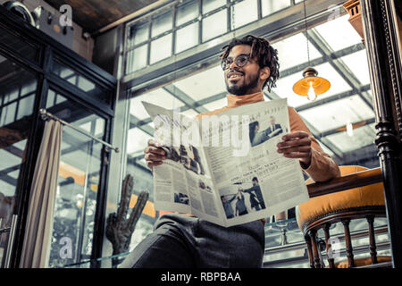 Piacere positivo persona maschio a gomito pendente sul tavolo Foto Stock