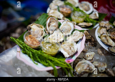 Ostriche fresche sul mercato locale di Trang. Tailandese tradizionale piatto a base di ingredienti freschi. Foto Stock