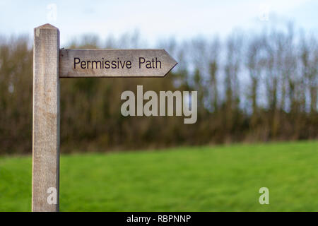 Un sentiero in legno punti di segno il titolo di "Percorso permissivo' con alberi e un prato in background Foto Stock