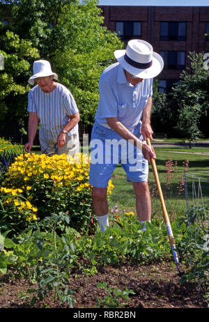 Un anziano giovane lavora in un giardino a un assisted living facility Foto Stock