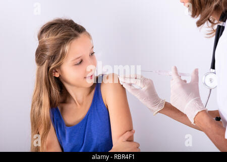 Close-up di un medico di iniettare una siringa al braccio del paziente in Clinica Foto Stock