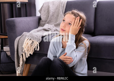 Close-up di un depresso ragazza seduta di fronte divano Foto Stock