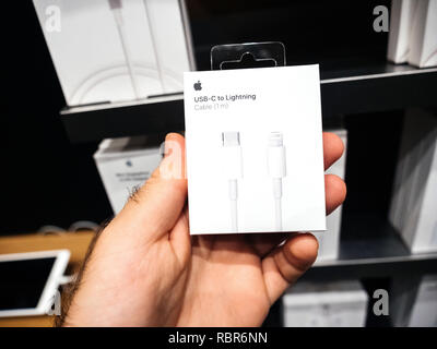 Parigi, Francia - Oct 25, 2018: Uomo con imballaggio di computer Apple USB-C al cavo di illuminazione all'interno di Apple Store Foto Stock